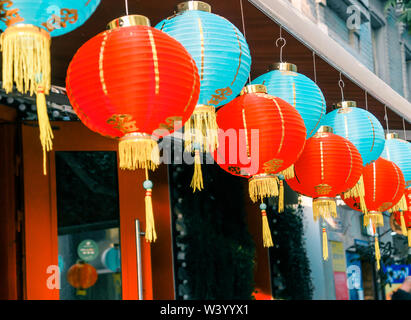 Lanternes de papier chinois sur l'oscillation de vent sur le toit d'un bâtiment par jour dans la rue Banque D'Images