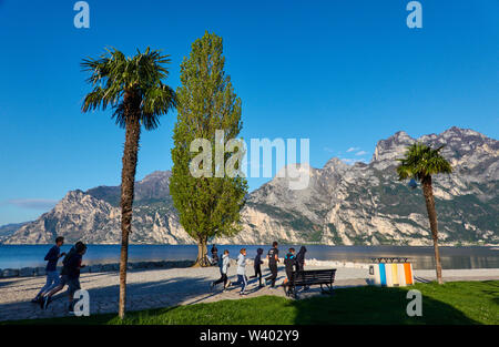 Jogger à North Beach le lever du soleil au petit port de Porticcioloat Lago di Garda, Lac de Garde à Torbole - Nago, Riva, , Italie au 15 avril 2019. Banque D'Images