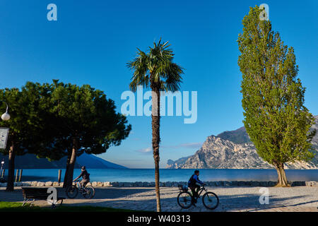 Les cyclistes à North Beach le lever du soleil au petit port de Porticcioloat Lago di Garda, Lac de Garde à Torbole - Nago, Riva, , Italie à 15 Avril, 2019 Banque D'Images