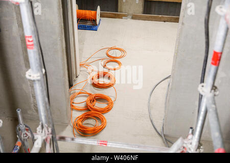 26 juin 2019, Saxe, Leipzig : Câbles pour l'installation électrique sont situés dans le shell de la soi-disant 'Lipsia Tower' dans le district de Leipzig-Grünau. Le même jour, l'écimage-out cérémonie a eu lieu pour la première réunification des tours dans le nouveau quartier de Leipzig Grünau des années 70 et 80. Dans l'avenir il y aura de 60 appartements sur 13 étages dans la chambre. La coopérative d'habitation Lipsia investit un bon 13 millions d'euros. Après des décennies d'abandon et la démolition de bâtiments préfabriqués vide, le nombre d'habitants est à la hausse pour la première fois. Photo : Jan Woi Banque D'Images