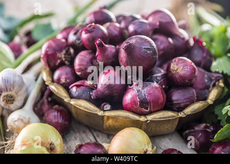 Oignon rouge en bronze de l'ail et fines herbes bol de céleri rave sur table de jardin - Haut de vue. Close-up de légumes frais sain Banque D'Images