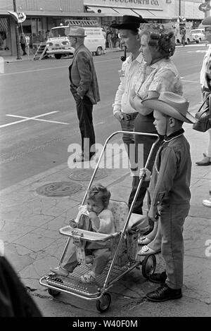 Groupe de la famille américaine caucasienne ensemble dans la rue l'homme fume un tuyau et porte un chapeau de cow-boy et sa femme est dans ses cheveux curlers également connu comme rouleaux de cheveux. Pendleton, Oregon 1969, États-Unis 60 États-Unis HOMER SYKES Banque D'Images