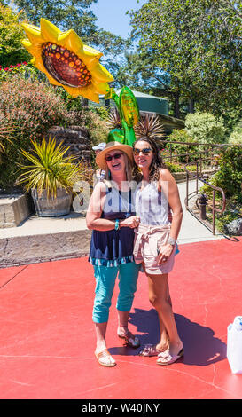 Deux femmes de la génération y célébrer l'un de leurs anniversaires avec un énorme ballon mylar en forme de soleil sur le patio au Nepenthe restaurant sur la route 1. Banque D'Images