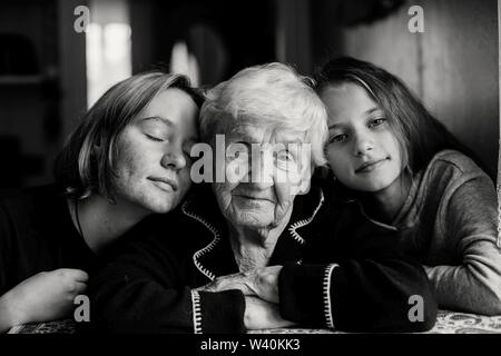 Petite-fille de deux filles s'embrasser sa grand-mère. Photo noir-blanc. Banque D'Images