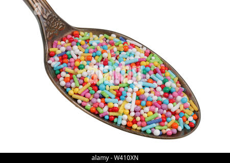 Dans l'ancienne coupe d'or il y a un petit tas de nourriture - a multi-colored sprinkles bonbons pour la décoration de gâteau. Isolé sur blanc macro studio Banque D'Images