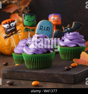 Ensemble de décoration de fête Halloween cupcakes en forme avec gingerbread cookies et cake pops avec funny monster est confrontée. Fond sombre, selective focus. Banque D'Images