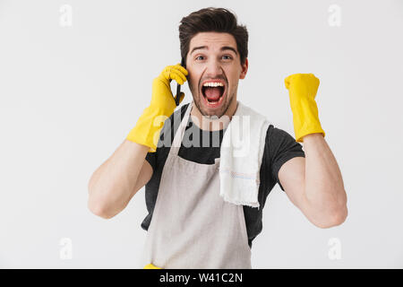 Belle brunette wearing apron houseman isolés sur fond blanc, talking on mobile phone Banque D'Images