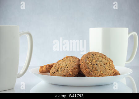 Café et biscuits. Le temps de vous détendre. Tasses blanc avec du café et de graines grillées. Banque D'Images