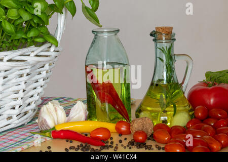 Les bouteilles avec de l'huile aromatisée. Saveurs de l'Italie. Le basilic, le poivre et l'ail. La préparation d'une salade.. Les tomates et saveurs de pizza. Banque D'Images