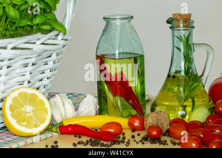 Les bouteilles avec de l'huile aromatisée. Saveurs de l'Italie. Le basilic, le poivre et l'ail. La préparation d'une salade.. Les tomates et saveurs de pizza. Banque D'Images