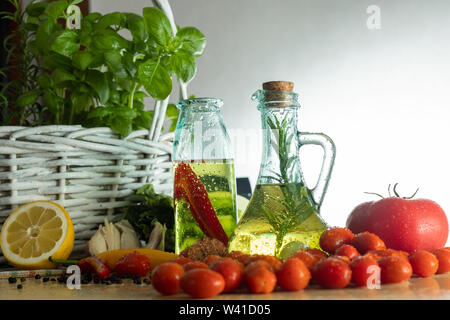 Les bouteilles avec de l'huile aromatisée. Saveurs de l'Italie. Le basilic, le poivre et l'ail. La préparation d'une salade.. Les tomates et saveurs de pizza. Banque D'Images