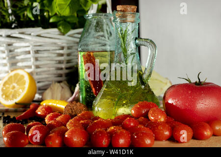 Les bouteilles avec de l'huile aromatisée. Saveurs de l'Italie. Le basilic, le poivre et l'ail. La préparation d'une salade.. Les tomates et saveurs de pizza. Banque D'Images