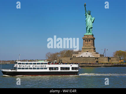 Statue de la liberté et de ferry touristique à New York Banque D'Images