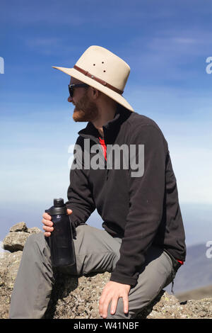 Homme aime le sport et les activités extrêmes. Se reposer sur le rocher haut dans le ciel. Belle nature sauvage de l'Afrique.montèrent sur le sommet de la montagne Banque D'Images