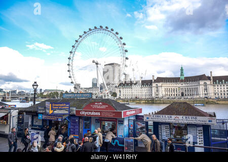 Les touristes d'acheter des billets de croisière de billetteries à Westminster Pier par Tamise avec London Eye en arrière-plan, Londres, Angleterre, Royaume-Uni Banque D'Images