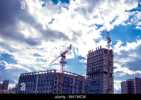 Grue de construction sur un chantier contre fond de ciel bleu. Banque D'Images