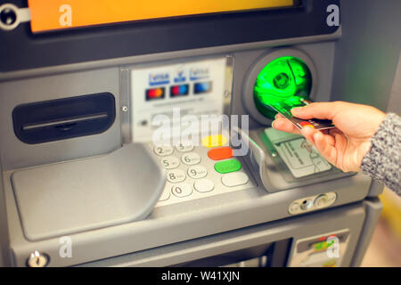 Finances, argent, banque et personnes concept - close up of hand saisie de code pin à l'extérieur de la machine atm Banque D'Images