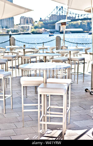 Compte tenu de l'étroite blanches rondes chaises et tables à manger à l'extérieur dans le patio ou à côté de la rivière côté eau de ville Brisbane, Queensland, Australi Banque D'Images