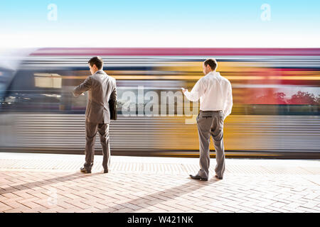 Bureau de deux personnes en attente d'un train à la gare, le soleil autour de la zone, le temps et les heures de pointe du matin, sol est carrelé, le ciel est clair. Banque D'Images