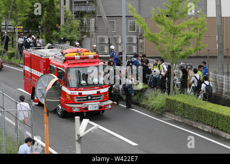 (190719) -- KYOTO, 19 juillet 2019 (Xinhua) -- un camion de pompiers passe par les journalistes d'attente près d'un studio d'Animation de Kyoto après la construction d'un incendie criminel à Kyoto, Japon, Juillet 19, 2019. Le motif derrière un prétendu incendie criminel dans un studio d'Animation Kyoto Co. à l'ouest du Japon, qui a tué 33 personnes un jour plus tôt, peut-être le vol d'idées, les sources a dit vendredi. Les médias locaux citant des sources d'enquête, a déclaré qu'un 41-year-old man appréhendés au cours de l'auteur présumé de l'incendie criminel a dit à la police qu'il a commencé l'incendie sur le studio de trois étages parce que la société 'stole un roman." (Xinhua/Du Xiaoyi) Banque D'Images