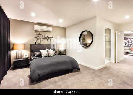 Chambre moderne avec un miroir rond et le couloir à travers la chambre de luxe Banque D'Images