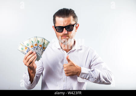 L'homme d'affaires barbu en chemise de la détention de monnaie et regardant la caméra sur fond blanc Banque D'Images