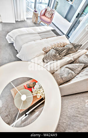 Chambre à coucher moderne high angle vue de dessus la lampe sur la petite table à côté d'oreillers et draps de lit à côté de portes en verre coloré, parfait également l Banque D'Images