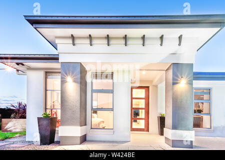 Maison moderne/close up avec portes et fenêtres à côté façade, notamment les grands piliers en béton illuminé par des lumières, le ciel est clair, sans nuages, Banque D'Images