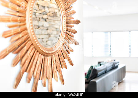 Miroir rond sur le mur avec des pièces de bois attaché à lui avec quelques sculpter close up dans un salon avec l'illumination du soleil Banque D'Images