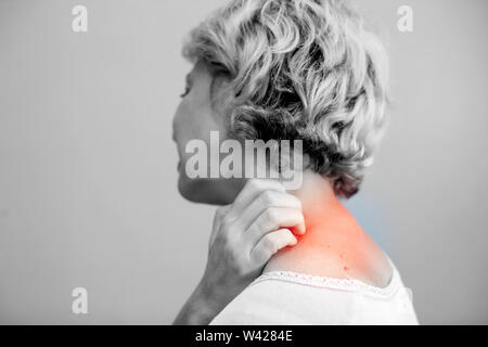 Femme de rayer une démangeaison sur fond blanc . La peau sensible, de l'alimentation des symptômes d'allergie, d'irritation Banque D'Images