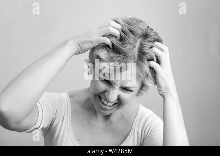 Femme de rayer sa tête isolé sur fond blanc. Chemin de détourage sur fond blanc Banque D'Images