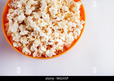 Une orange bowl with popcorn isolé sur fond blanc. Concept alimentaire Banque D'Images