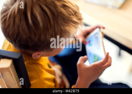 Les enfants, de la technologie et internet concept. Petit garçon enfant souriant jouer à des jeux ou surfer sur internet sur smartphone numérique Banque D'Images