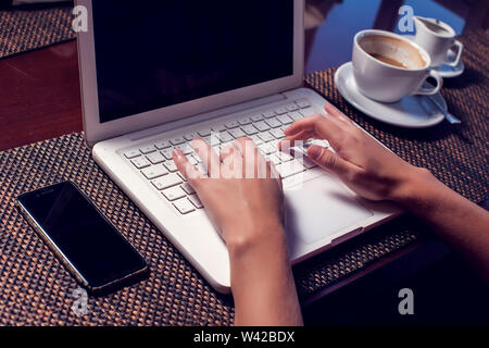 Les personnes, la technologie, la communication et les loisirs concept. Cropped rear view of woman's hands sur ordinateur portable Internet surf, contrôle rss via net social Banque D'Images