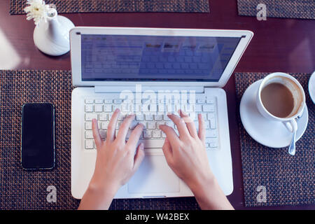 Les personnes, la technologie, la communication et les loisirs concept. Cropped rear view of woman's hands sur ordinateur portable Internet surf, contrôle rss via net social Banque D'Images