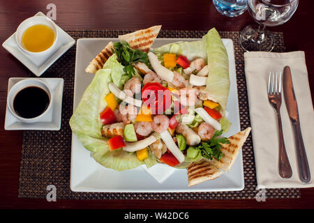 Salade de fruits de mer avec des sauces sur plaque blanche. Banque D'Images