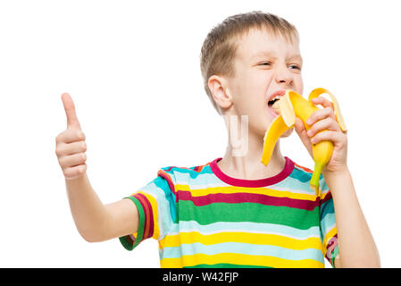 Happy boy mange banane savoureux sur fond blanc, portrait est isolé Banque D'Images