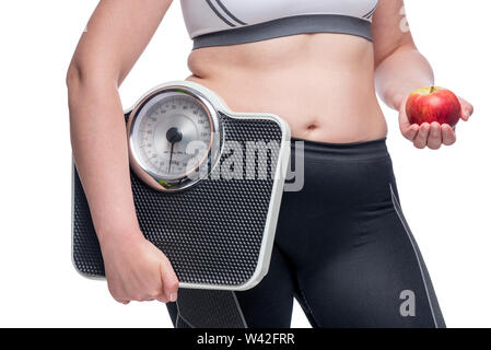 Grosse femme avec des poids et une pomme fait un choix en faveur du sport et de la saine alimentation photo concept Banque D'Images