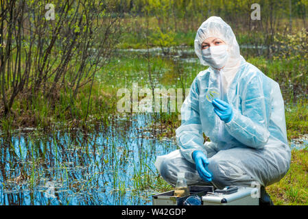 Chimiste écologiste avec des échantillons d'eau et des plantes de la forêt river mène des recherches Banque D'Images