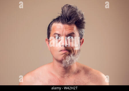 Portrait d'un homme avec la moitié de la barbe et cheveux sur fond brun Banque D'Images