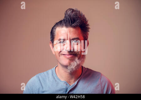 Portrait d'un homme avec la moitié de la barbe et cheveux sur fond brun Banque D'Images