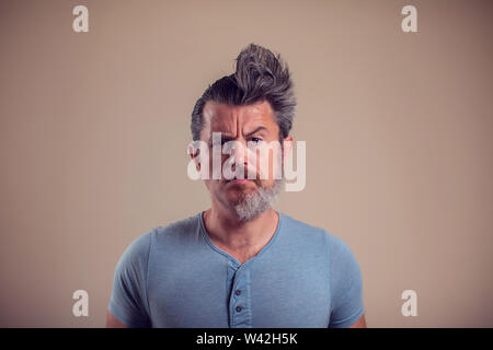 Portrait d'un homme avec la moitié de la barbe et cheveux sur fond brun Banque D'Images