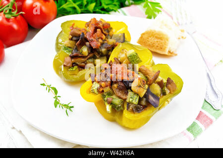 Doux poivron farci aux champignons, tomates, courgettes, aubergines et oignons, assaisonnés avec du vin, l'ail, le thym et les épices dans une assiette blanche sur la cuisine Banque D'Images
