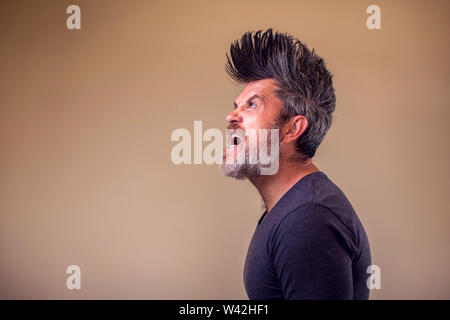 Closeup portrait d'un homme adulte en colère avec une barbe et iroquois. Les gens et les émotions concept Banque D'Images