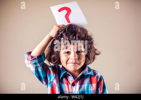 Kid garçon avec point d'interrogation. Les enfants, l'éducation, les émotions concept Banque D'Images