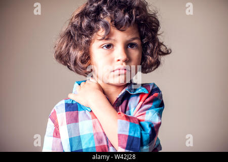 Un garçon tenant son cou douloureux. Les enfants, les soins de santé, medicine concept Banque D'Images