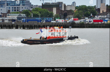 GPS remorqueur Cambria sur Tamise avec une queue pour Woolwich ferry en arrière-plan, London, England, UK Banque D'Images