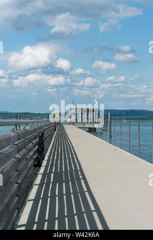 Altnau, TG / Suisse - 14. Juillet 2019 : longue jetée en béton in donnant sur le lac de Constance sous un ciel d'été Banque D'Images