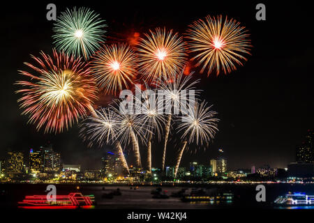 D'artifice coloré festif illuminent le ciel au-dessus de la ville la nuit scène pour maison de vacances festival et fête fond Banque D'Images