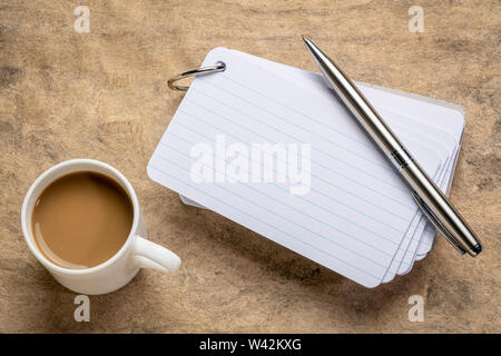 Une pile de cartes vierges avec une tasse de café et un stylo contre le papier d'écorce texturée Banque D'Images